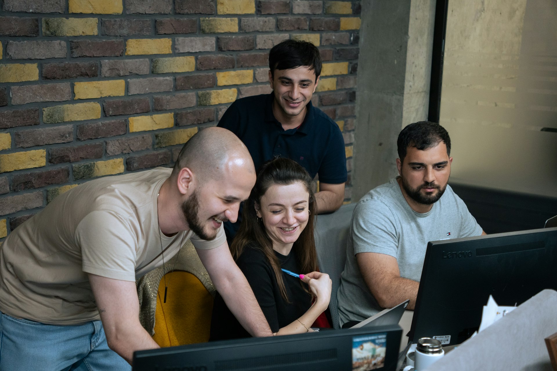Business leaders and companies exploring AI adoption to drive growth and efficiency AI Adoption for Business Leaders | Growth & Efficiency with AIA group of people sitting around a laptop computer